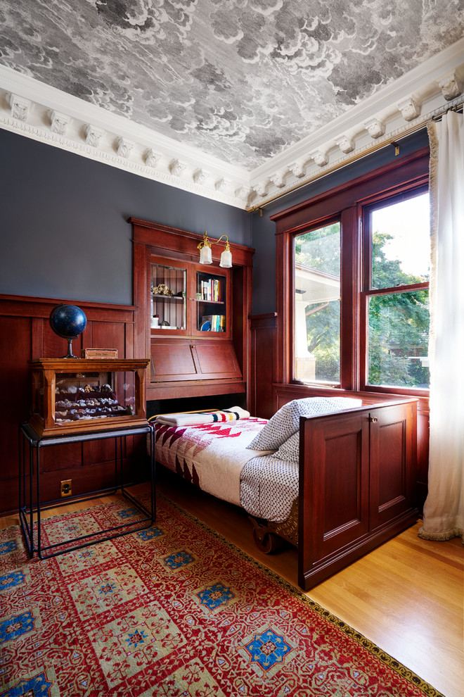 Elegant guest medium tone wood floor and brown floor bedroom photo in Portland with gray walls