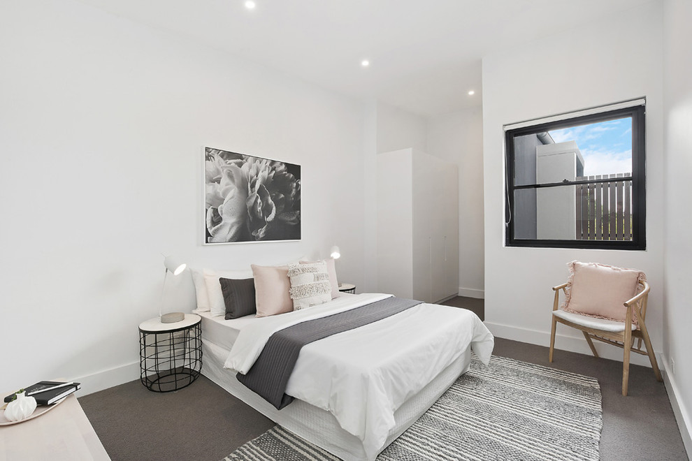 Imagen de dormitorio principal actual con paredes blancas, moqueta y suelo gris