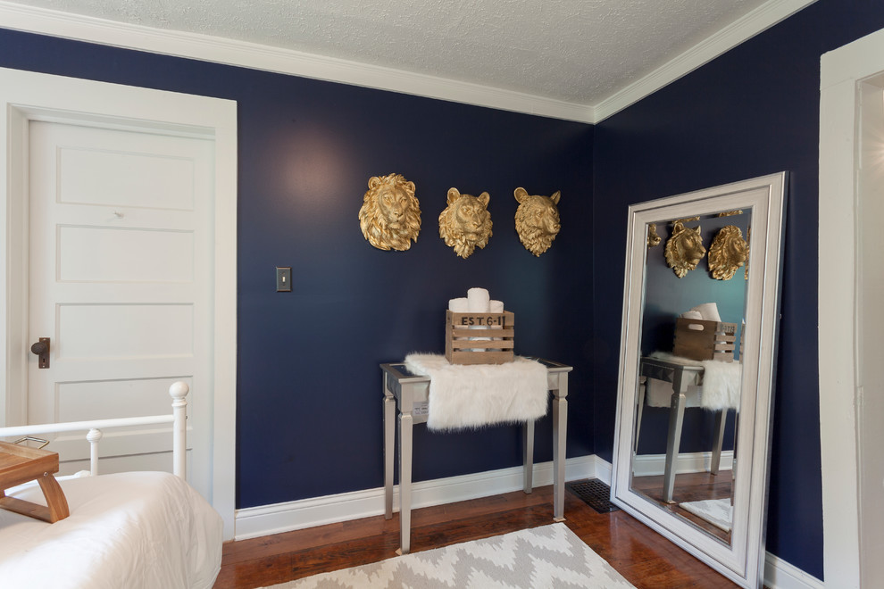 Idées déco pour une petite chambre d'amis éclectique avec un mur bleu et un sol en bois brun.