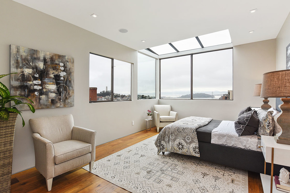 Aménagement d'une chambre d'amis contemporaine avec un mur beige et un sol en bois brun.