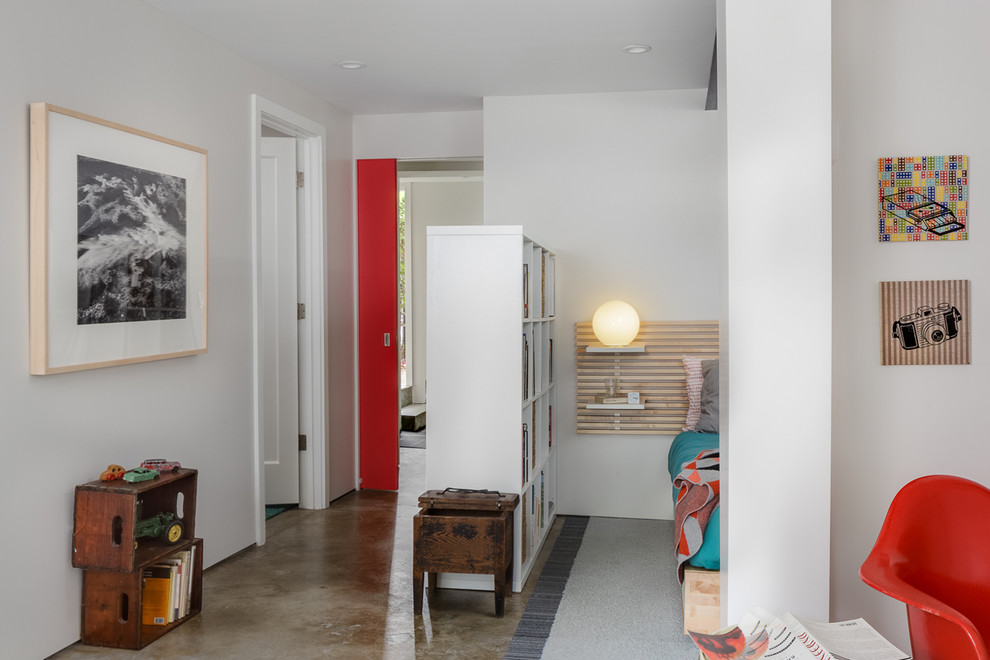 Modelo de habitación de invitados minimalista de tamaño medio sin chimenea con paredes blancas y suelo de cemento