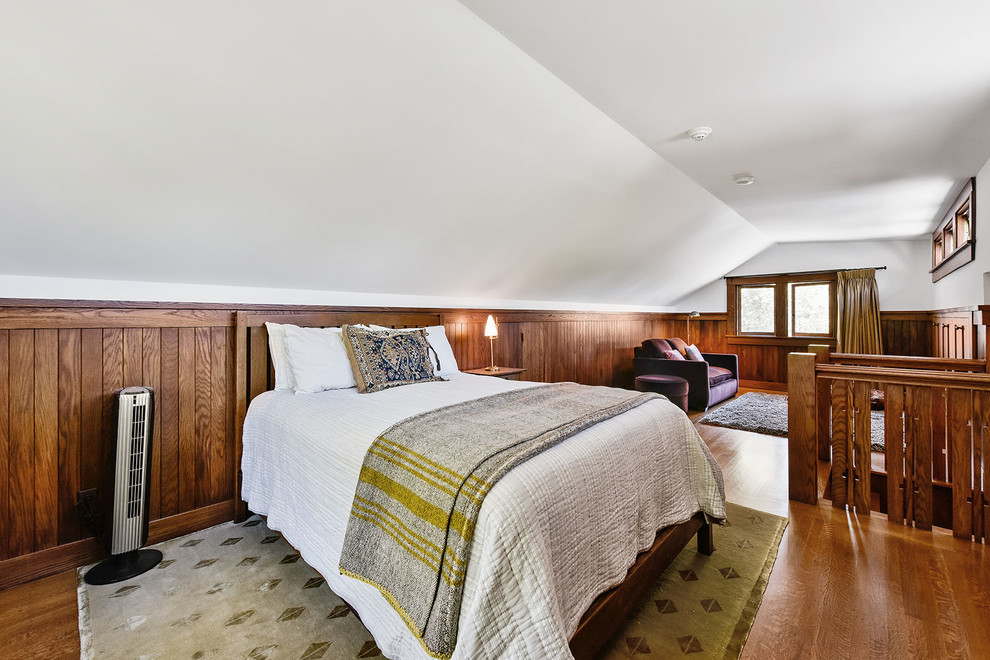 Modelo de habitación de invitados de estilo americano pequeña con paredes multicolor y suelo de madera en tonos medios