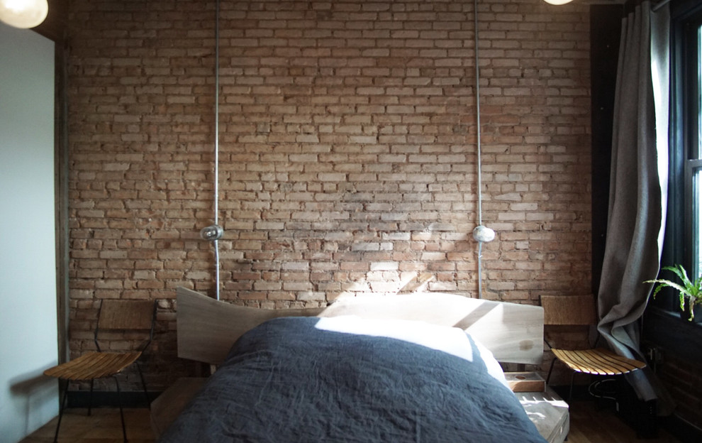 Modelo de dormitorio principal urbano de tamaño medio con paredes blancas y suelo de madera clara