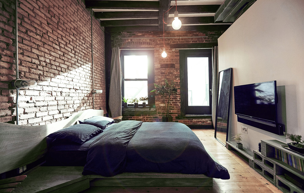 Ejemplo de dormitorio principal urbano de tamaño medio con paredes blancas y suelo de madera clara