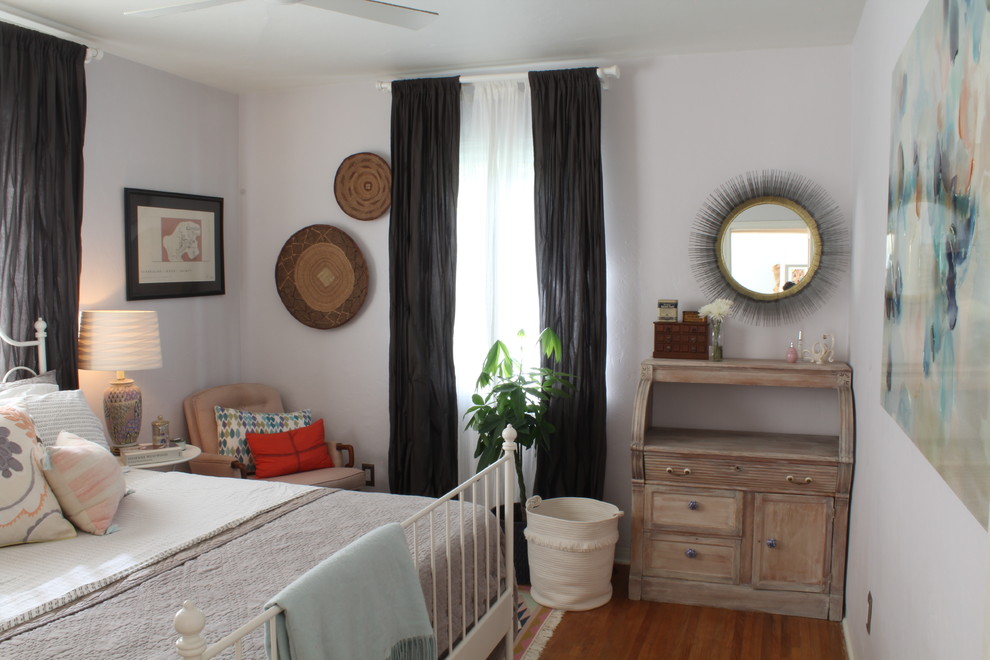 Foto de dormitorio principal ecléctico pequeño sin chimenea con paredes púrpuras, suelo de madera clara y suelo marrón