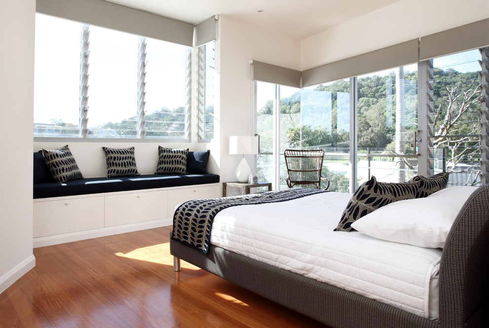 Mittelgroßes Modernes Hauptschlafzimmer ohne Kamin mit weißer Wandfarbe und braunem Holzboden in Sunshine Coast