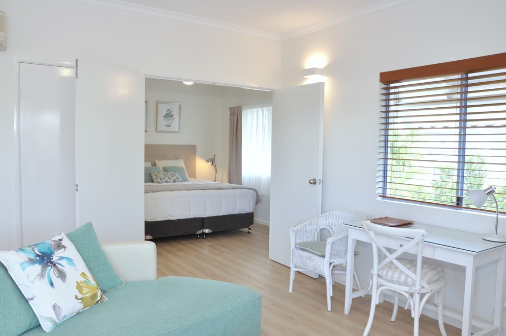 Diseño de dormitorio principal costero con paredes blancas, suelo vinílico y suelo beige