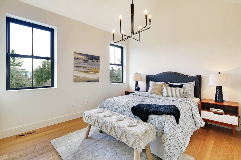 Example of a large danish guest medium tone wood floor and brown floor bedroom design in Seattle with white walls