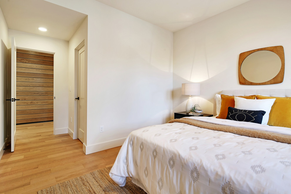 Mittelgroßes Skandinavisches Gästezimmer mit weißer Wandfarbe, braunem Holzboden und braunem Boden in Seattle
