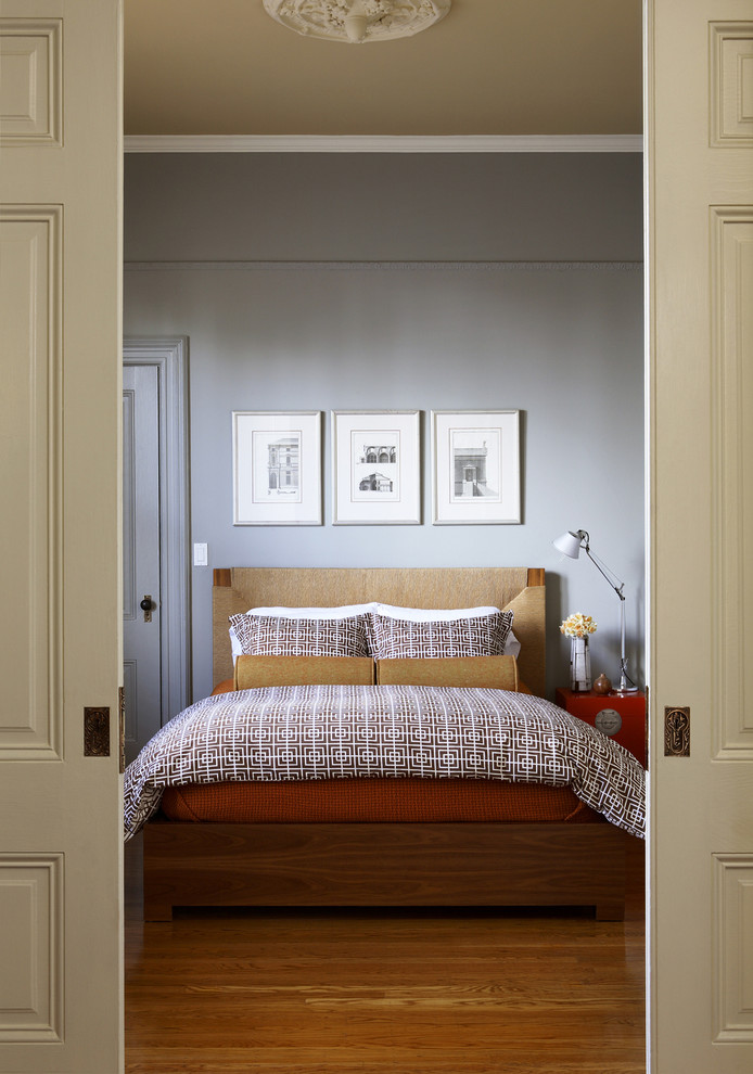 Example of a transitional medium tone wood floor and beige floor bedroom design in San Francisco with gray walls