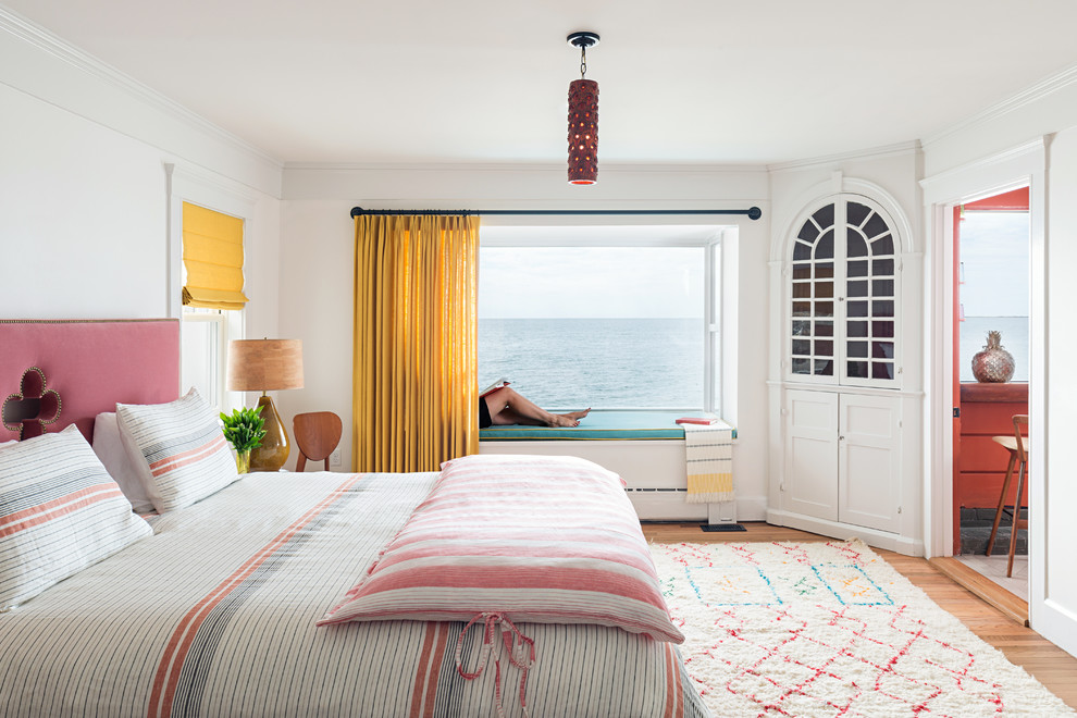Diseño de dormitorio principal costero de tamaño medio con paredes blancas y suelo de madera clara