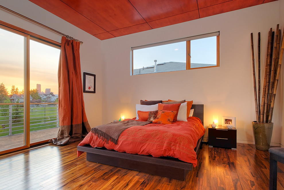 Réalisation d'une chambre minimaliste avec un mur beige, un sol en bois brun et un sol orange.