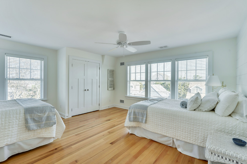 Immagine di una grande camera da letto stile marinaro con pareti bianche, parquet chiaro e nessun camino