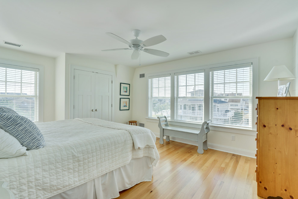 Mittelgroßes Maritimes Schlafzimmer ohne Kamin mit gelber Wandfarbe und hellem Holzboden in Philadelphia