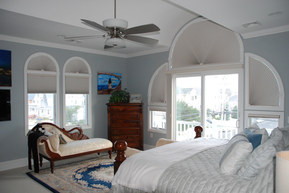 Immagine di una grande camera matrimoniale costiera con pareti blu, moquette e nessun camino