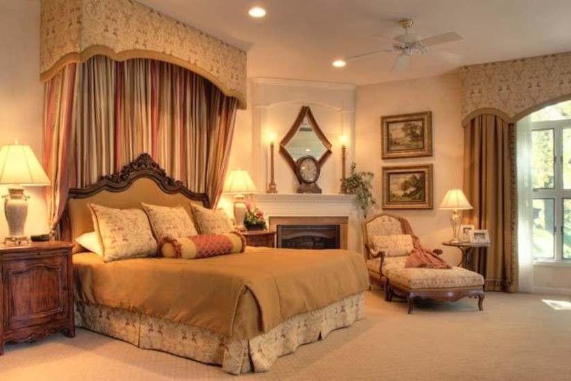 シーダーラピッズにある広いトラディショナルスタイルのおしゃれな主寝室 (ベージュの壁、カーペット敷き、標準型暖炉、木材の暖炉まわり)