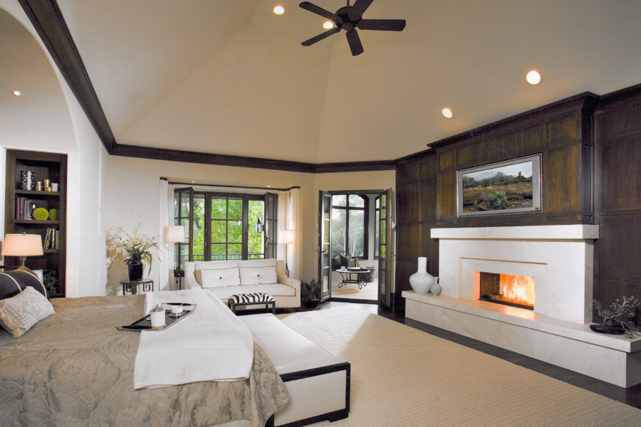 Expansive classic master bedroom in Chicago with beige walls, dark hardwood flooring, a standard fireplace and a stone fireplace surround.