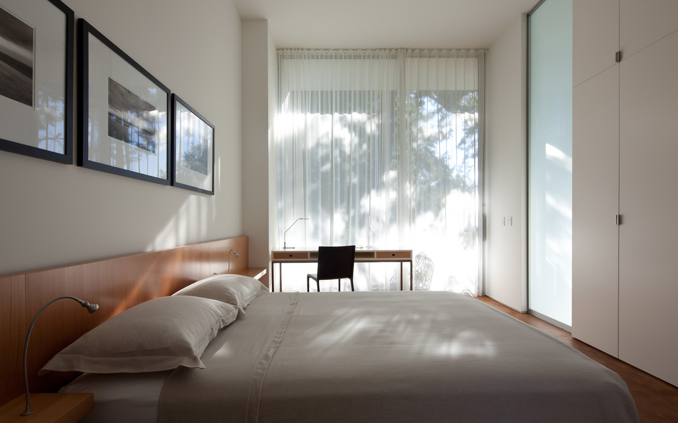 На фото: спальня в стиле модернизм с белыми стенами и паркетным полом среднего тона с