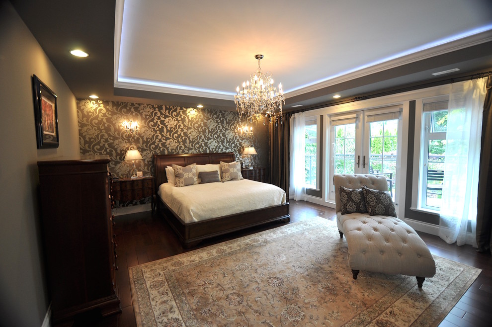 This is an example of a large master bedroom with grey walls, dark hardwood flooring, a two-sided fireplace, a plastered fireplace surround and brown floors.