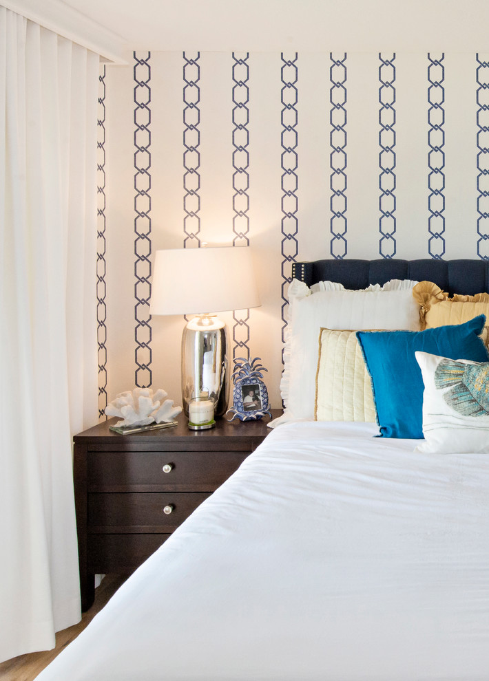 Imagen de habitación de invitados costera de tamaño medio sin chimenea con paredes multicolor y suelo de madera clara