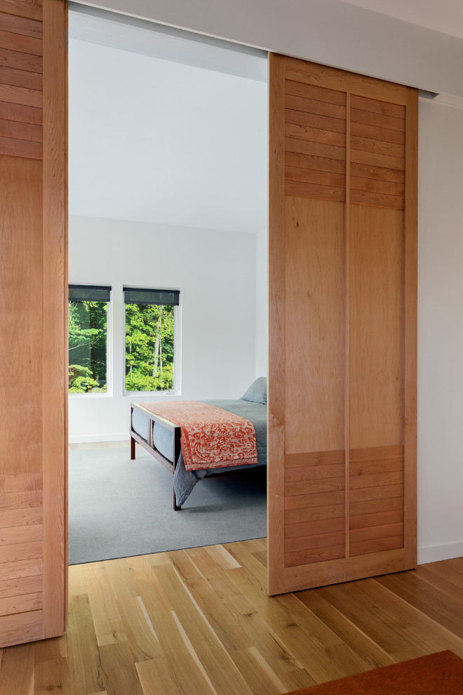 Idee per una camera matrimoniale minimalista di medie dimensioni con pareti bianche e pavimento in legno massello medio