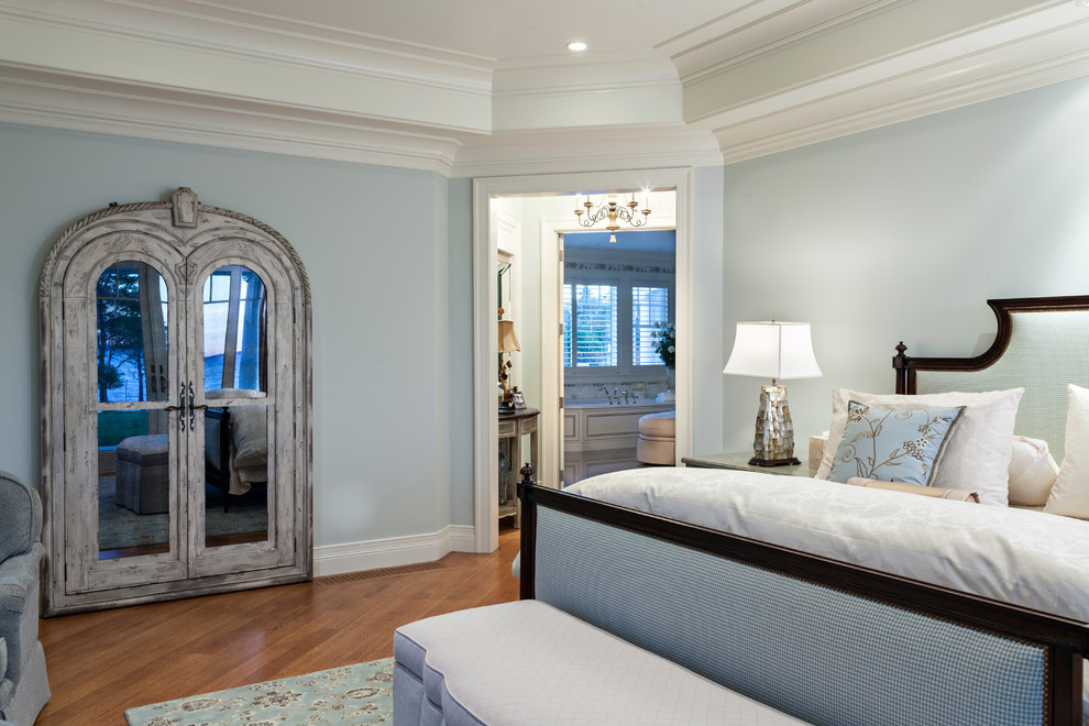 Imagen de dormitorio principal costero con paredes azules, suelo de madera en tonos medios y suelo marrón