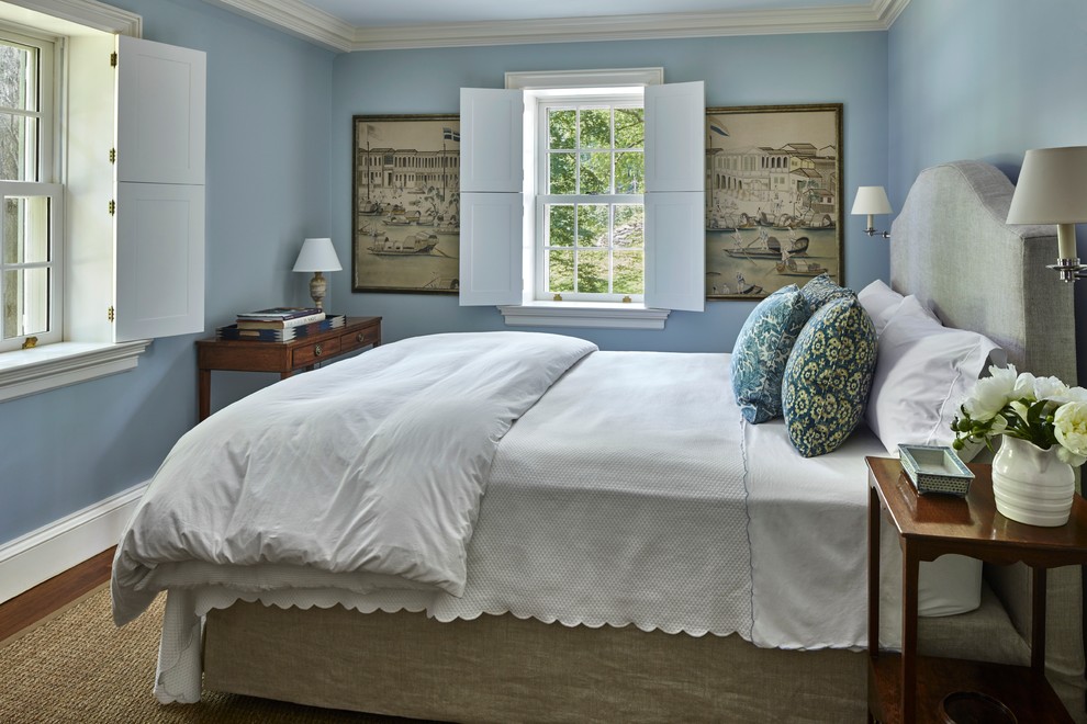 Diseño de habitación de invitados clásica de tamaño medio sin chimenea con paredes azules, suelo de madera oscura y suelo marrón