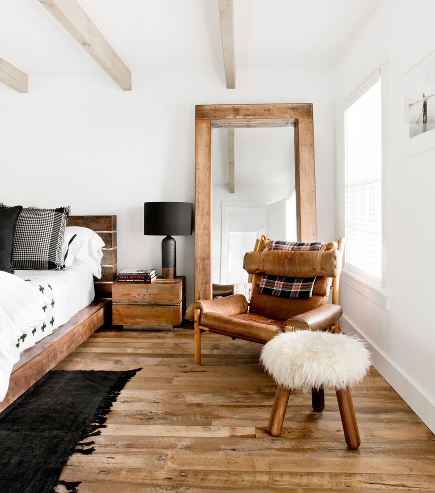 Großes Landhausstil Gästezimmer mit weißer Wandfarbe, hellem Holzboden und braunem Boden in New York
