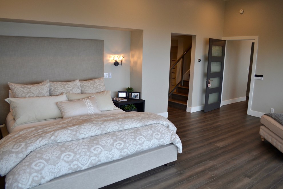 Foto de dormitorio principal actual de tamaño medio con paredes grises, chimenea de esquina, marco de chimenea de metal, suelo de madera oscura y suelo marrón
