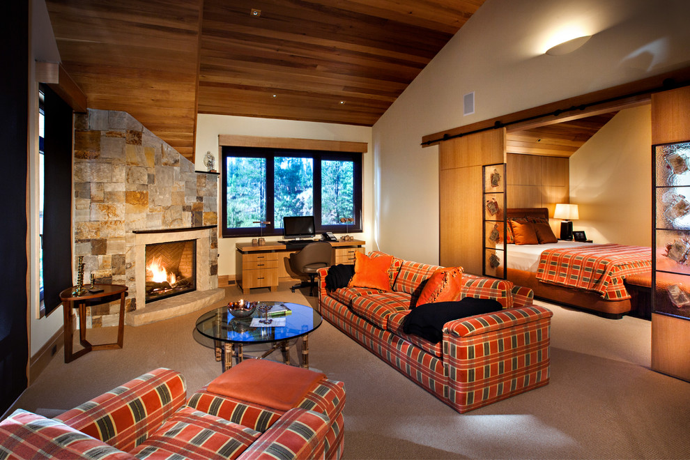 Rustikales Schlafzimmer mit beiger Wandfarbe, Teppichboden, Kaminumrandung aus Stein und Eckkamin in Denver