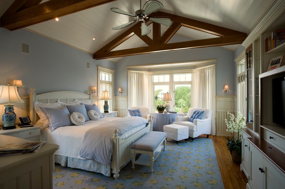 Modelo de dormitorio costero con paredes azules y suelo de madera en tonos medios