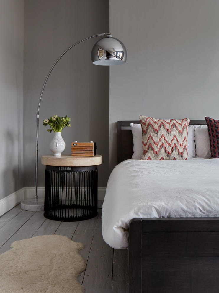Contemporary grey and silver bedroom in London with grey walls and light hardwood flooring.