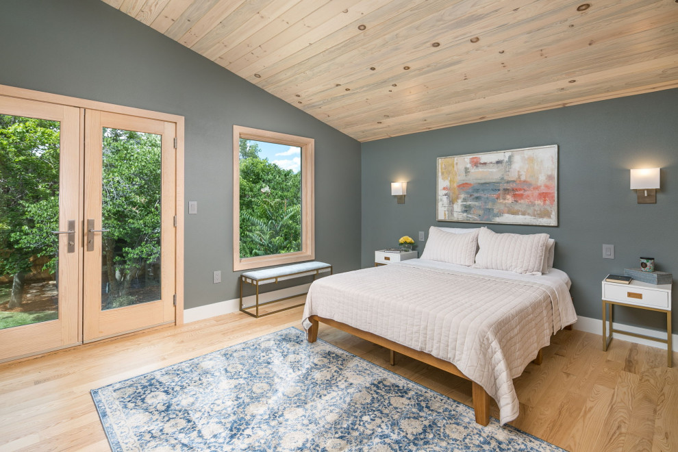 Modelo de habitación de invitados abovedada contemporánea pequeña con paredes multicolor, suelo de madera clara y suelo beige