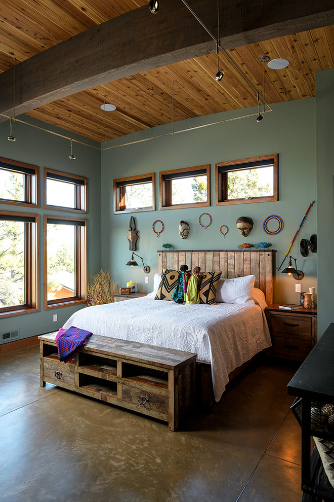 Ejemplo de dormitorio bohemio con paredes verdes y suelo marrón