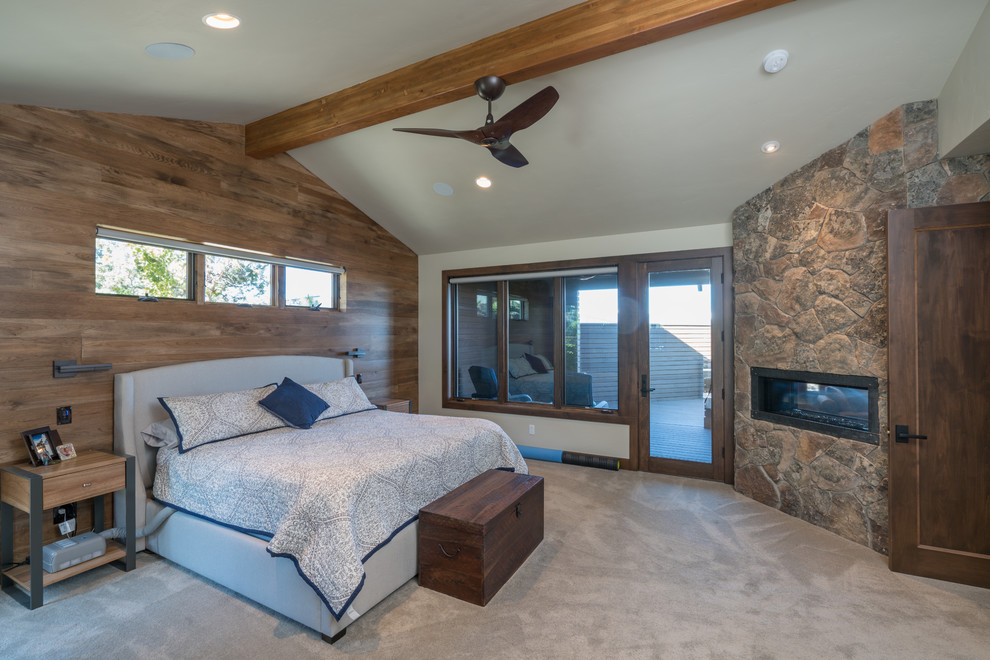 Inspiration for a large craftsman master carpeted bedroom remodel in Other with a two-sided fireplace and a stone fireplace