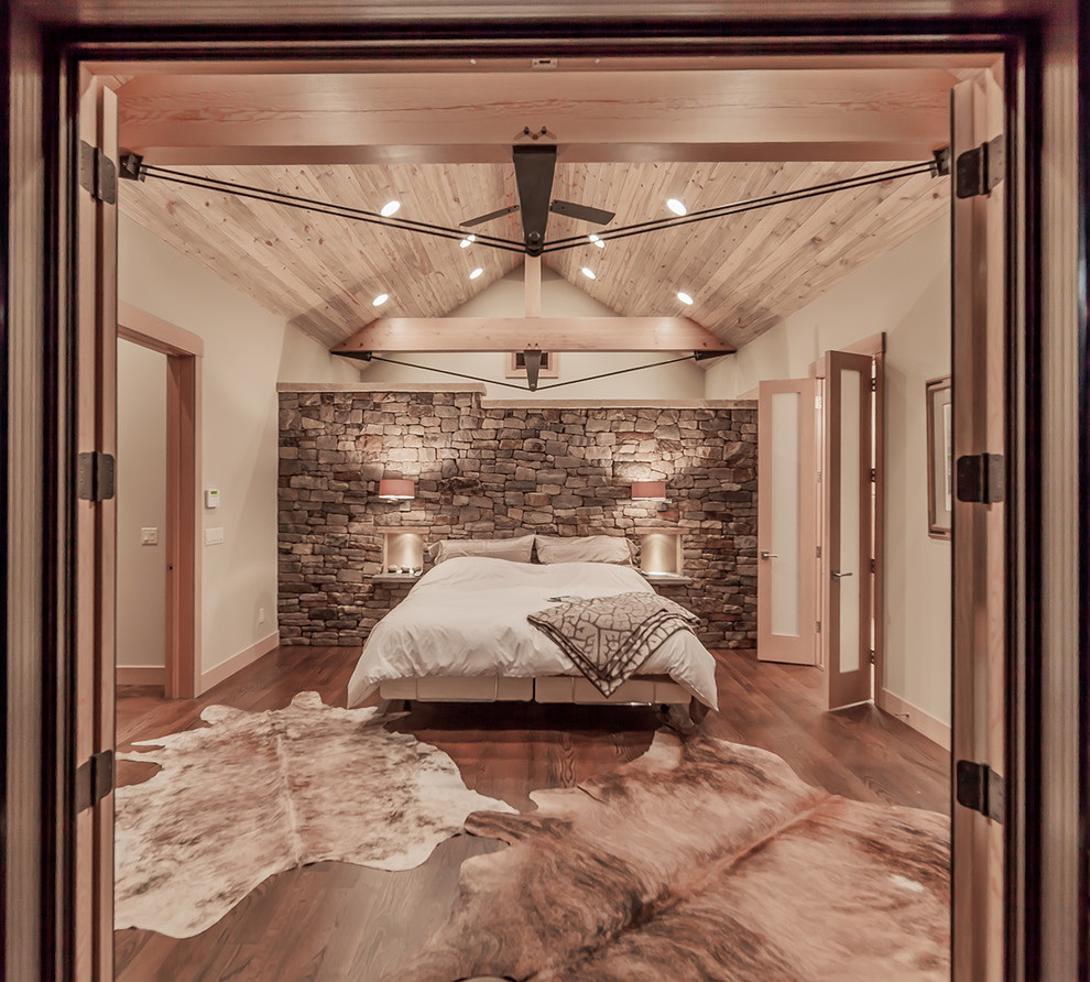 Foto de dormitorio rural con paredes beige y suelo de madera oscura