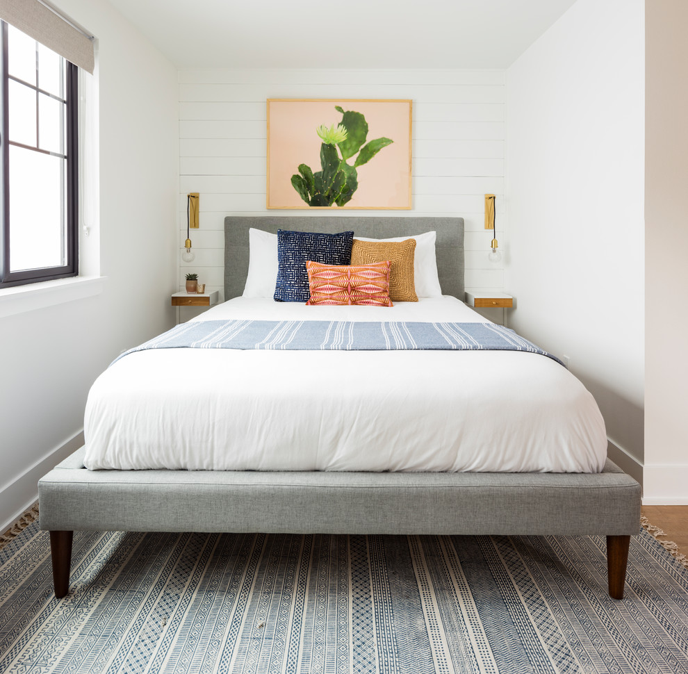 シアトルにある小さな北欧スタイルのおしゃれな客用寝室 (白い壁、ラミネートの床、暖炉なし、茶色い床、グレーとブラウン)