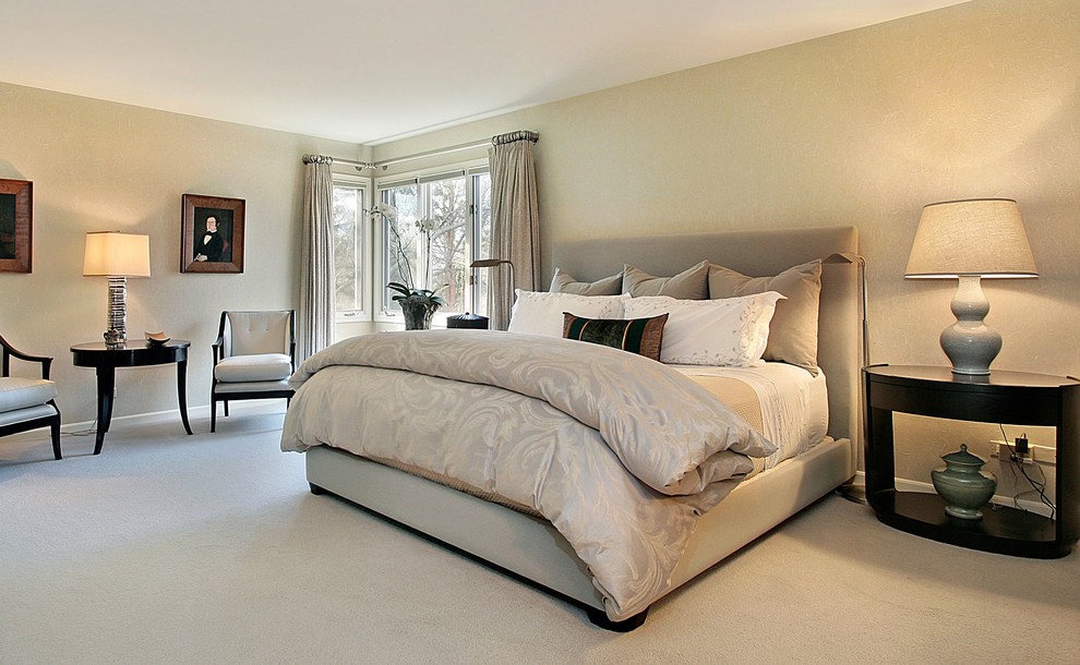 This is an example of a large classic master bedroom in Chicago with beige walls, carpet and no fireplace.