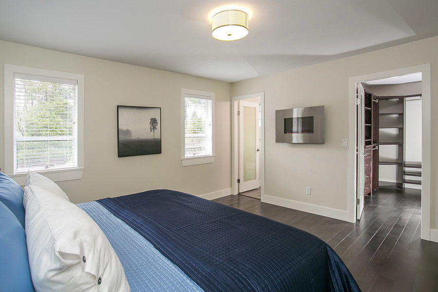 Cette image montre une chambre parentale minimaliste de taille moyenne avec un mur blanc, parquet foncé, une cheminée ribbon, un manteau de cheminée en métal et un sol marron.