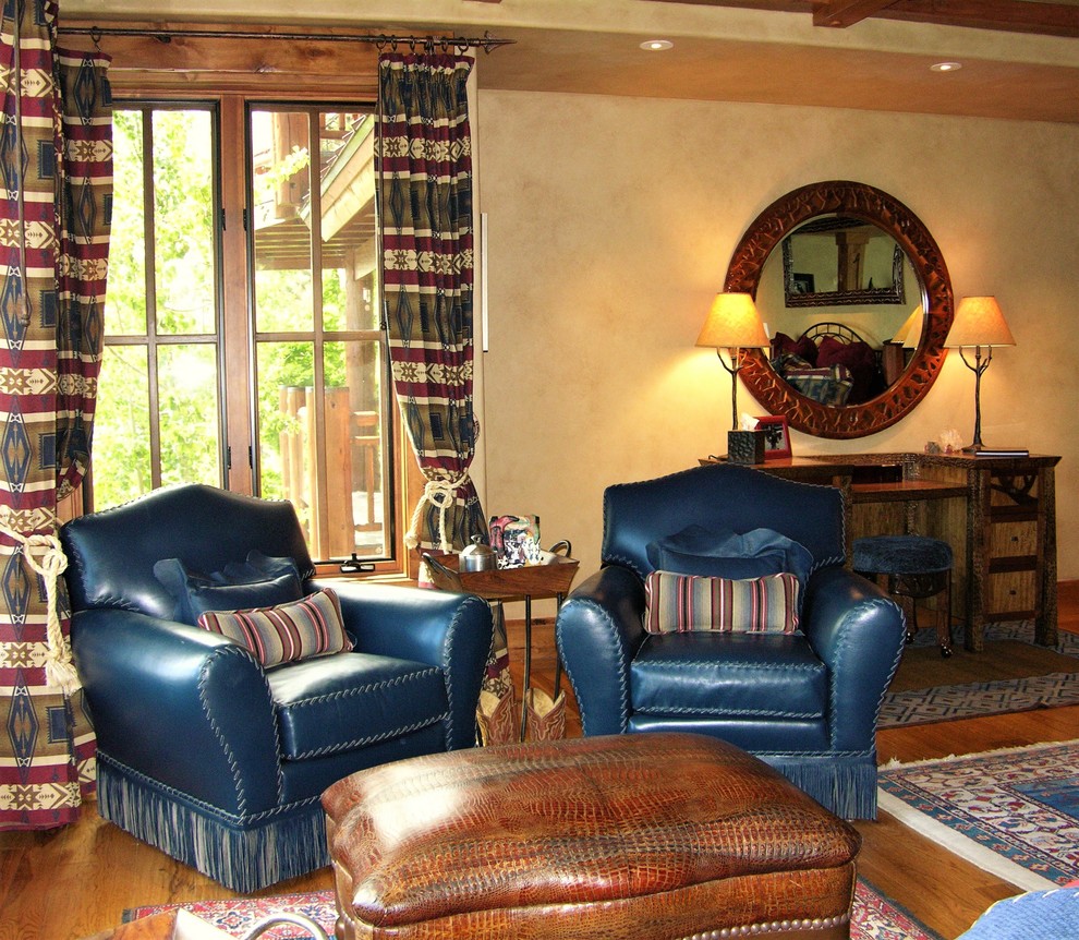 Exempel på ett rustikt sovrum, med beige väggar, mellanmörkt trägolv, en öppen vedspis och en spiselkrans i sten