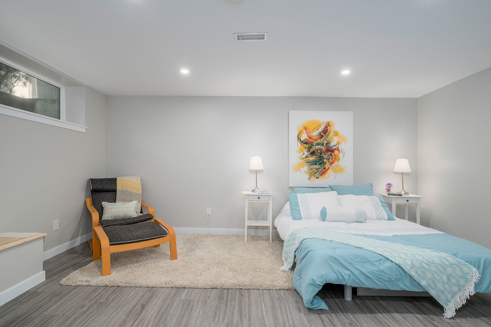 Foto de habitación de invitados actual de tamaño medio sin chimenea con paredes grises, suelo de madera oscura y suelo gris