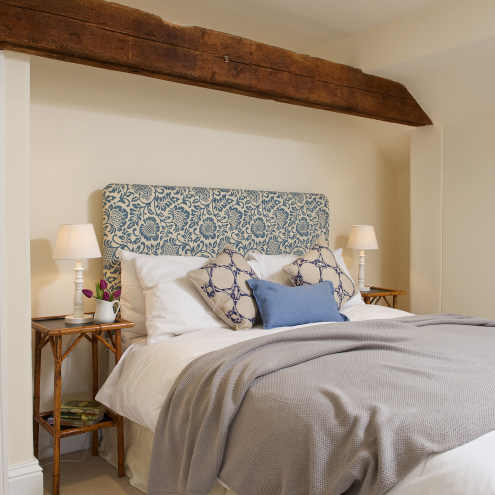 Immagine di una camera da letto country con pareti beige e moquette