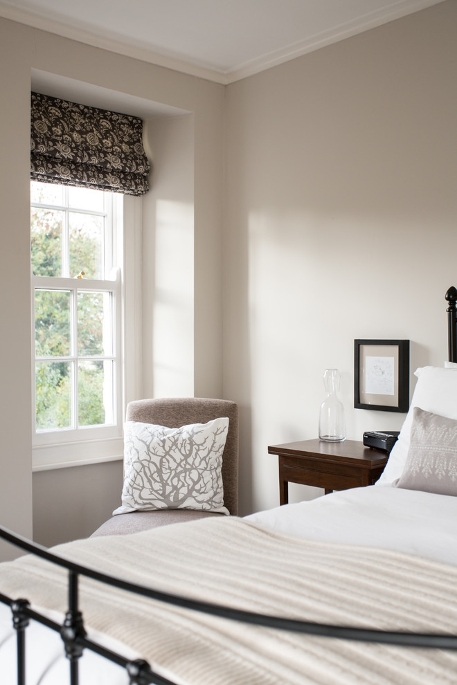 Ejemplo de habitación de invitados campestre de tamaño medio sin chimenea con paredes beige y moqueta