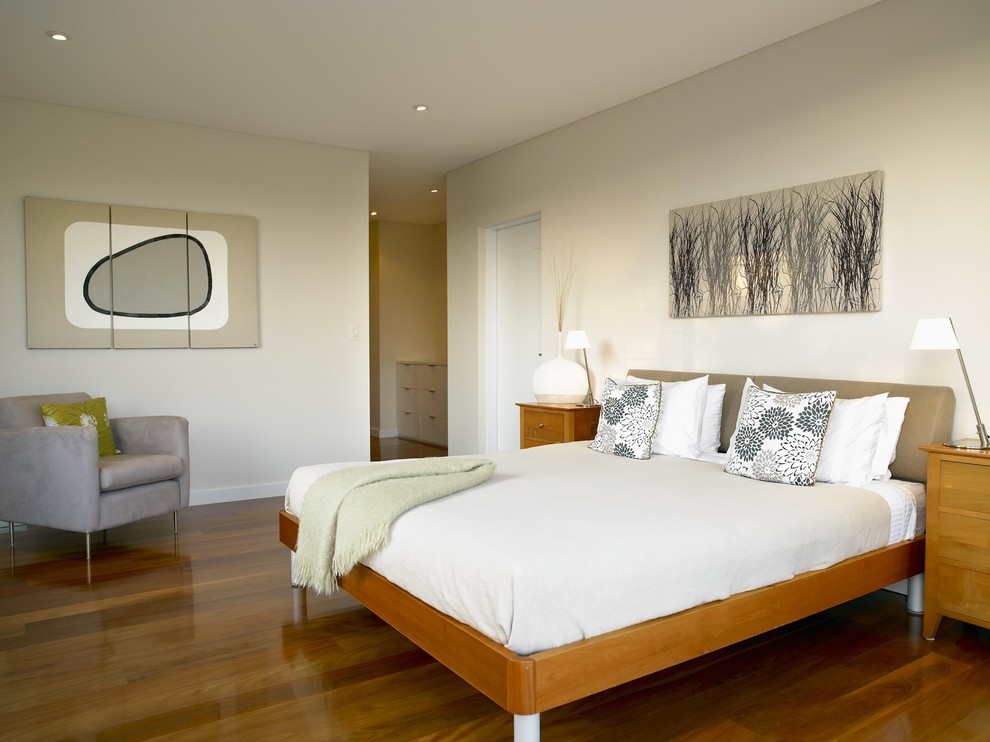 Ejemplo de dormitorio actual con suelo de madera en tonos medios
