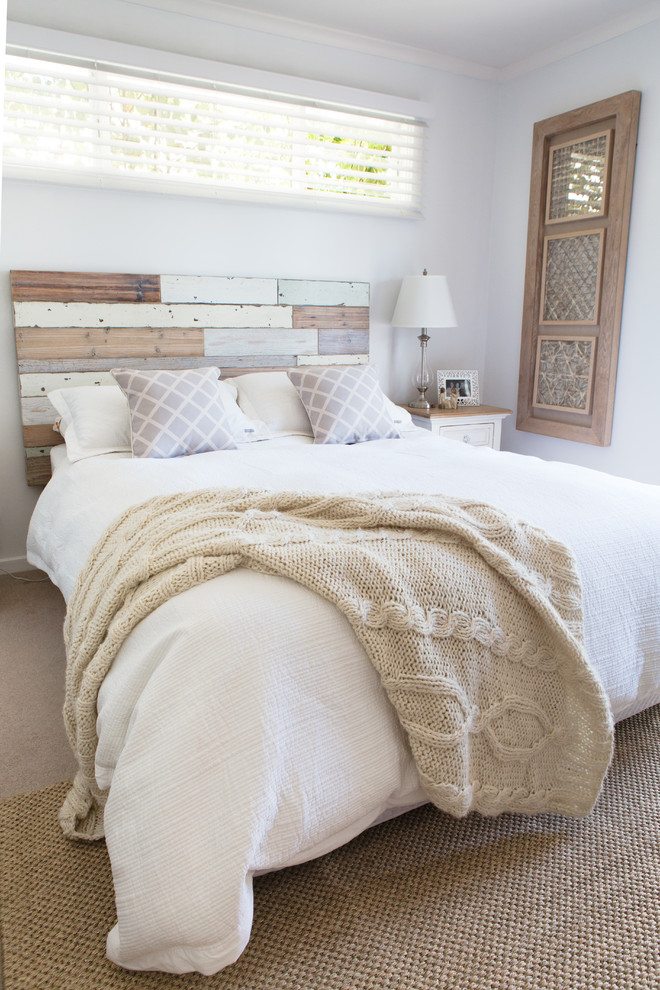 This is an example of a medium sized coastal master bedroom in Sydney with white walls and carpet.
