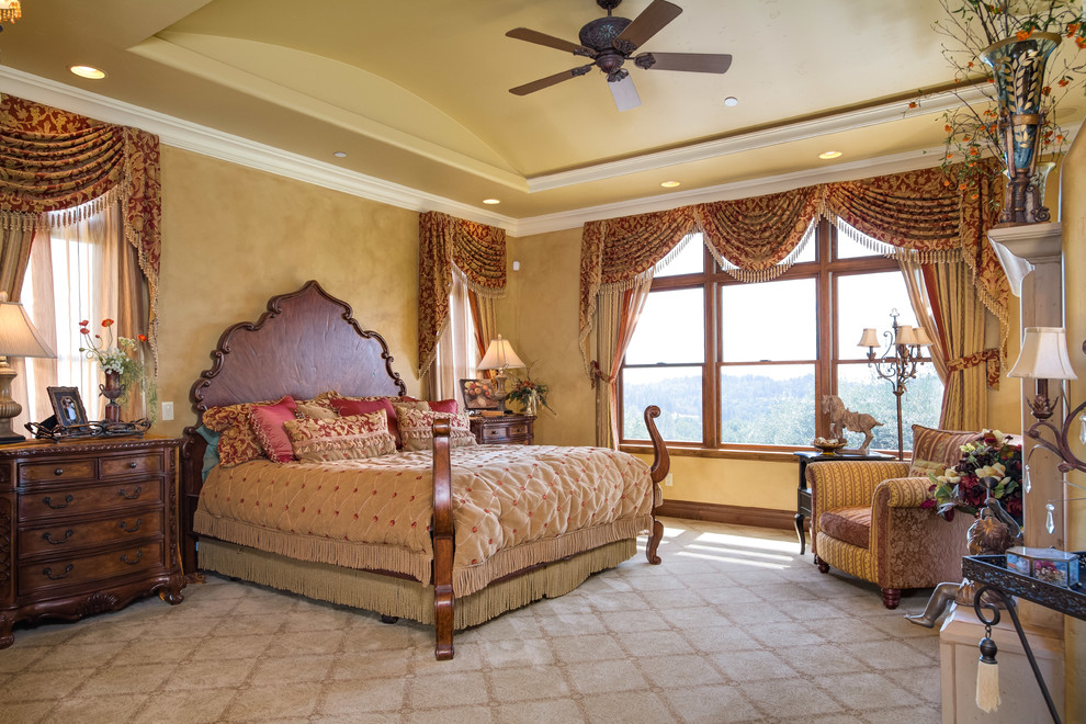Пример оригинального дизайна: большая хозяйская спальня в средиземноморском стиле с бежевыми стенами, ковровым покрытием и стандартным камином