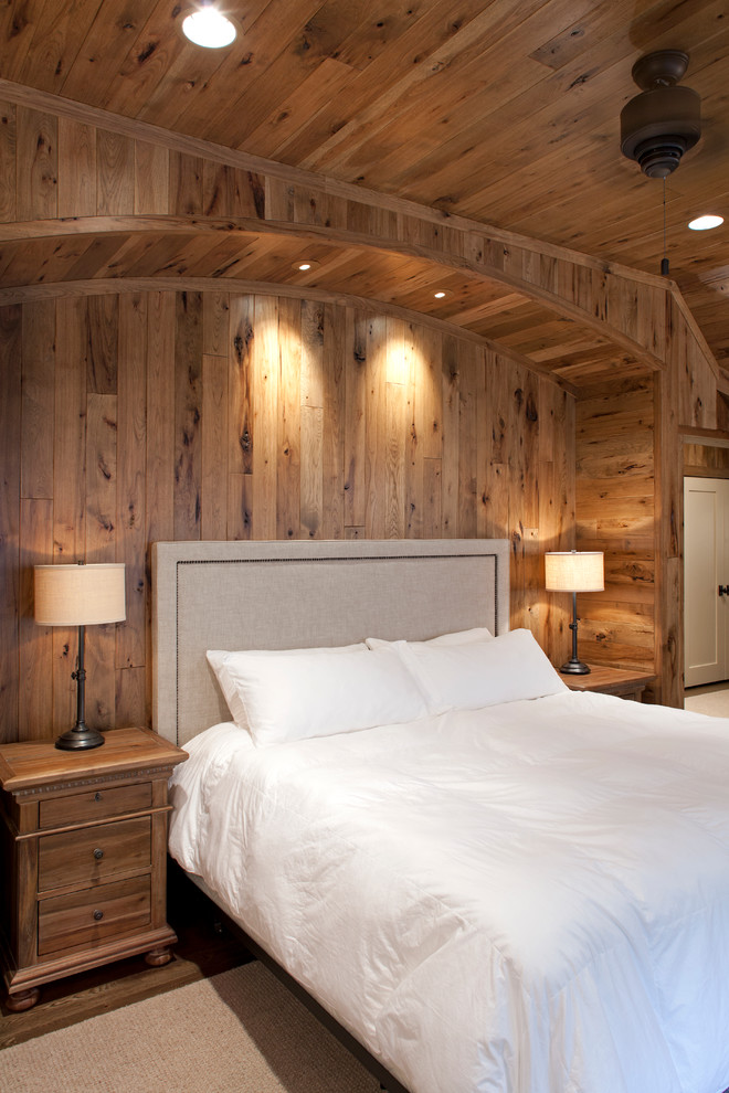 Immagine di una camera degli ospiti rustica con pareti marroni e pavimento in legno massello medio