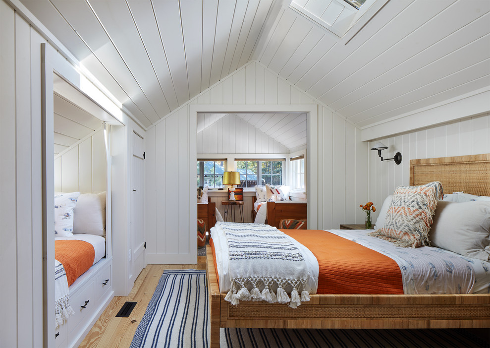 Ejemplo de habitación de invitados rural con paredes blancas, suelo de madera en tonos medios y suelo marrón