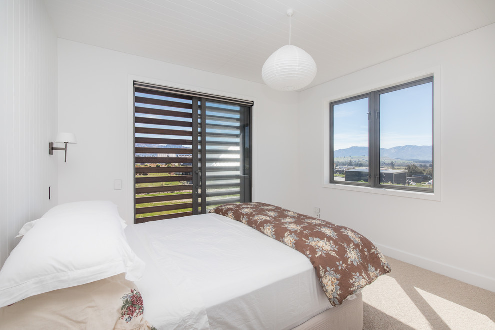 Imagen de habitación de invitados campestre con paredes blancas, moqueta y suelo beige