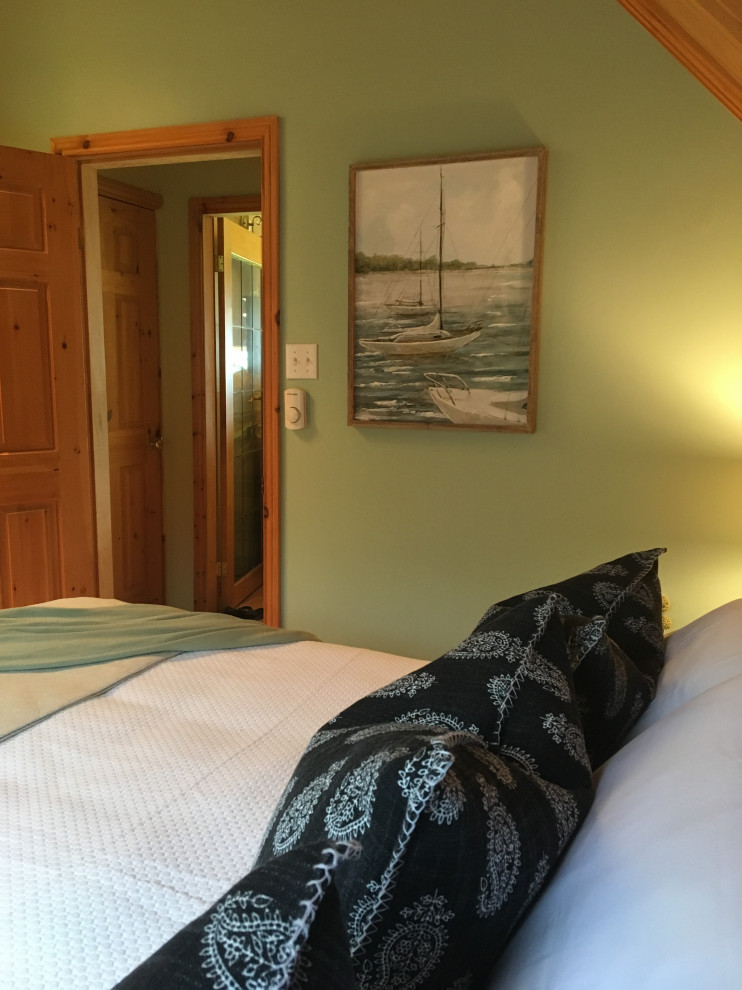 Cette photo montre une petite chambre d'amis bord de mer avec un mur vert, sol en stratifié et un sol orange.